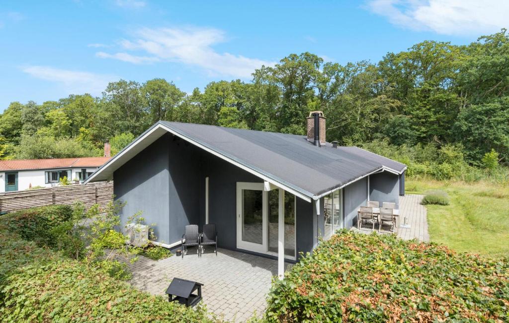 una casa negra con terraza y sillas en Beautiful Home In Ebeltoft With Wifi, en Ebeltoft