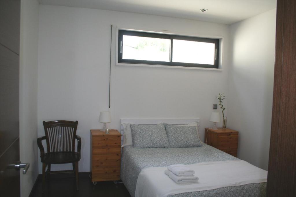a bedroom with a bed with a window and a chair at Casa Vallromanes BCN in Vallromanas