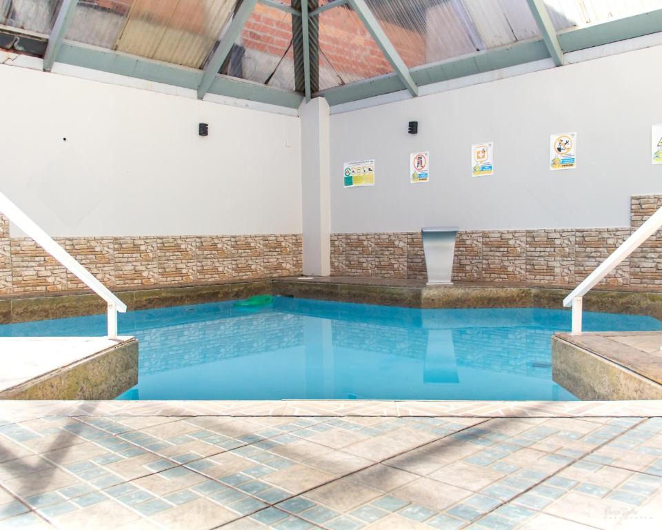 una piscina con agua azul en un edificio en De Rose Palace Hotel, en Torres