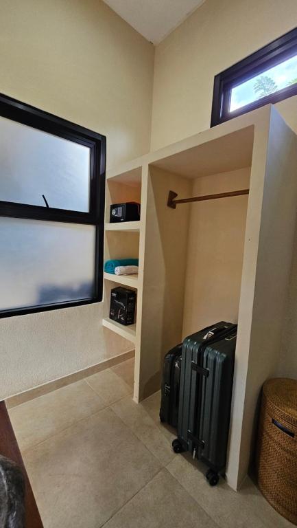 a room with a large window and luggage in it at LM Home Mendira in Candidasa