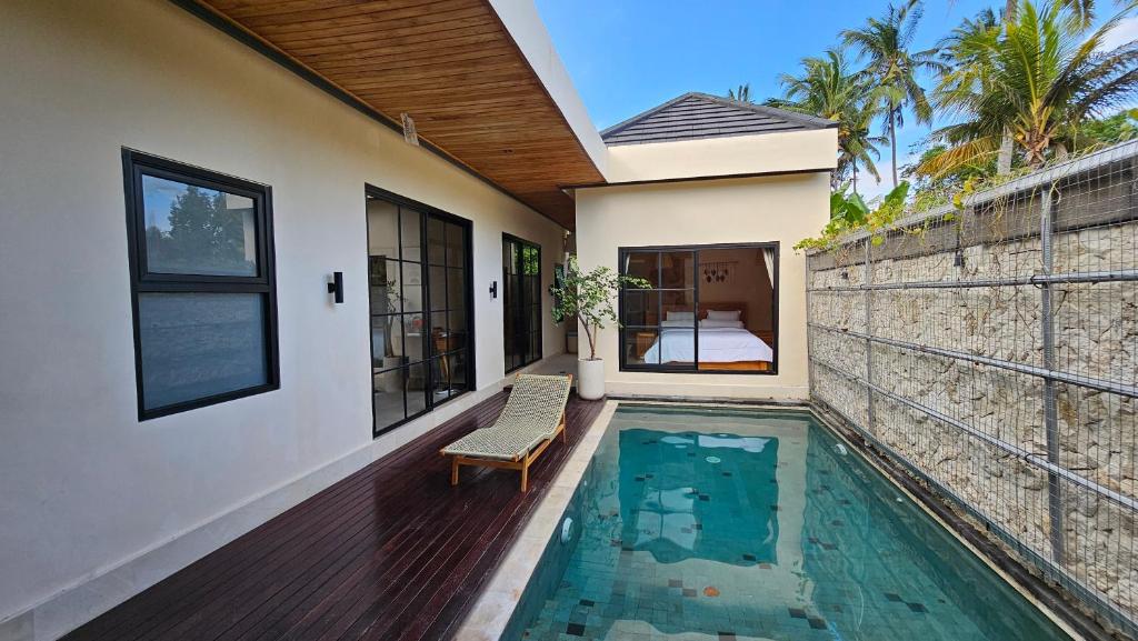 a house with a swimming pool next to a building at LM Home Mendira in Candidasa