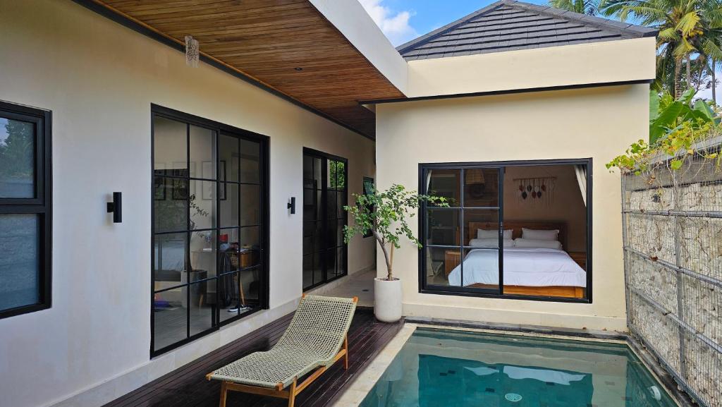 a house with a bedroom and a swimming pool at LM Home Mendira in Candidasa