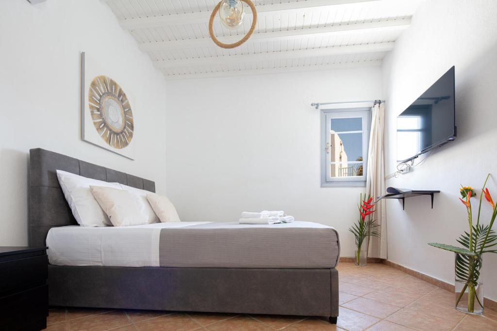 a bedroom with a bed with a clock on the wall at Aristeas Studio in Ornos