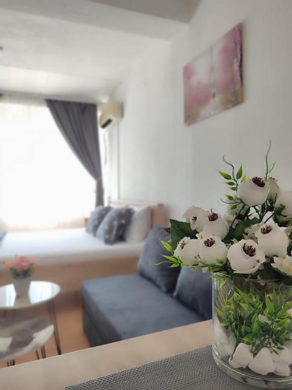 a vase of flowers sitting on a table in a living room at Happiness Apartment Skopje in Skopje