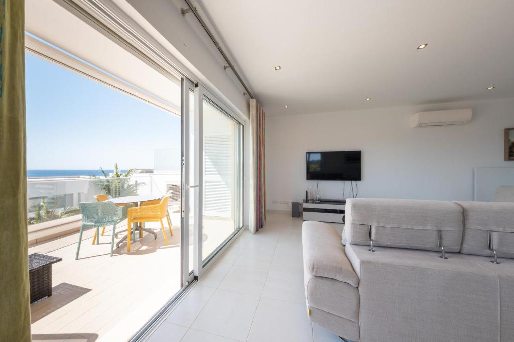 a living room with a couch and a view of the ocean at Porto de Mos 69 by Destination Algarve in Porto de Mós