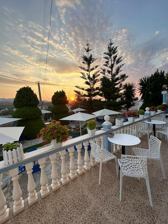 a balcony with tables and chairs and the sunset at Esmeralda Hotel & Restaurant in Ksamil