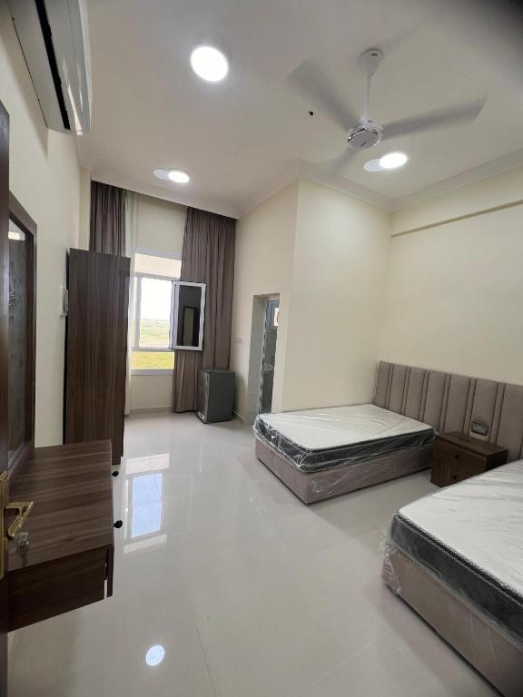 a large room with two beds and a tv at بناية حمران-RED-9-Hamren in Ma‘mūrah
