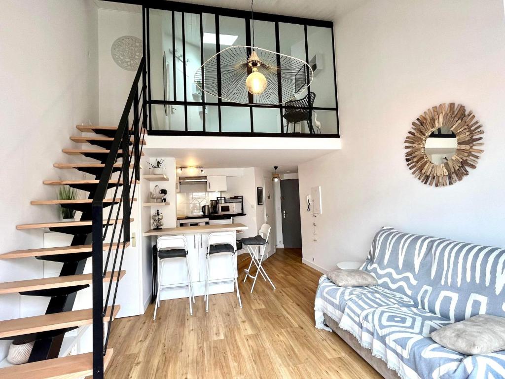 a living room with a spiral staircase and a kitchen at Appartement idéalement situé in Les Sables-dʼOlonne