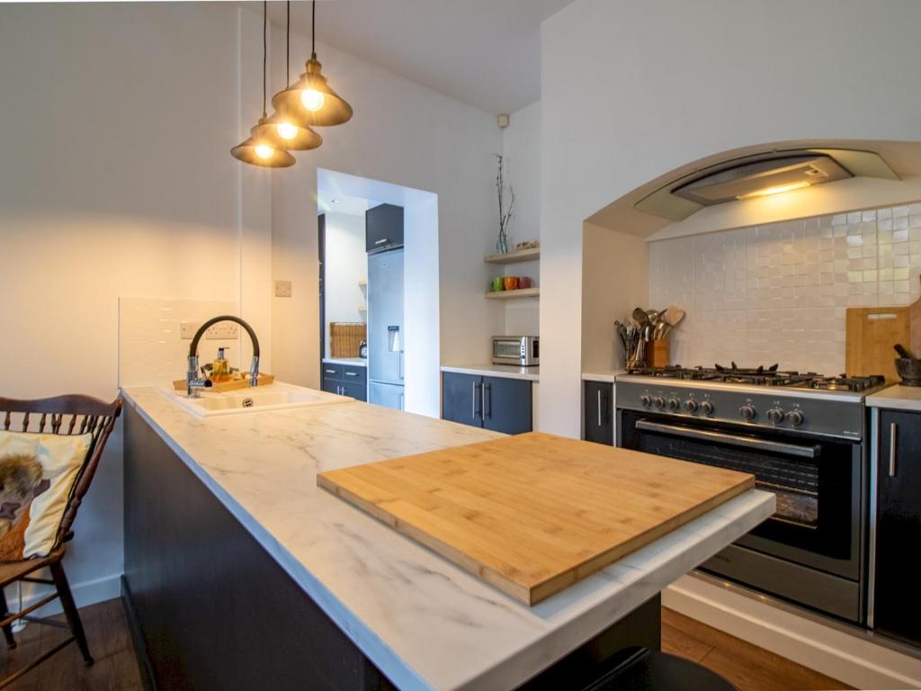 a kitchen with a wooden cutting board on a counter at Chic Beamish Retreat Stylish 3-Bed Near Durham - Pass the Keys in Stanley