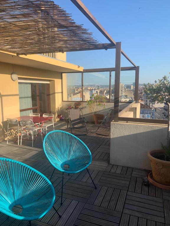 - deux chaises bleues sur une terrasse avec vue sur un bâtiment dans l'établissement Joli appartement avec belle terrasse, à Marseille