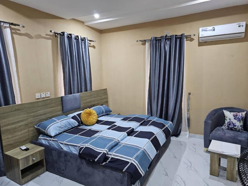 a bedroom with a bed and a chair at Skyline Apartments in Lagos