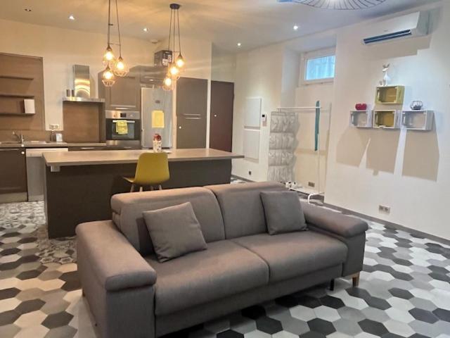 un salon avec un canapé et une cuisine dans l'établissement Appartement idealement situé, à Nice