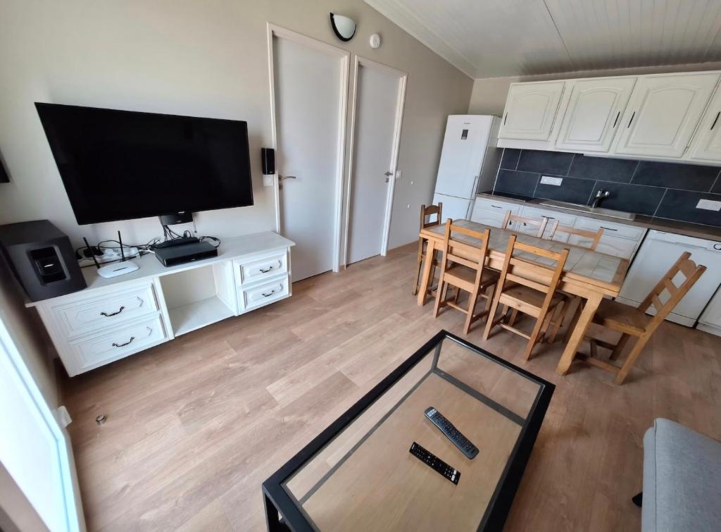 un salon avec une table et une cuisine avec une télévision dans l'établissement Maisonnette 40m2 type mobil-home, à Saint-Vit
