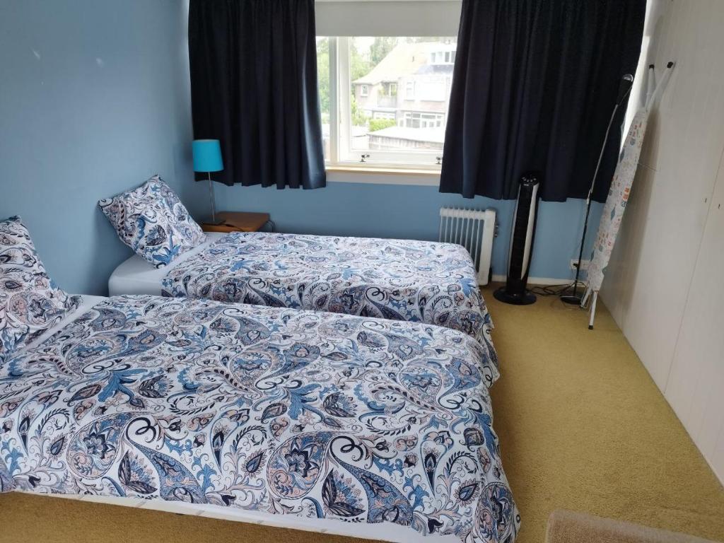 a bedroom with two beds and a window at Tranquil Retreat - Guest House in Arnhem