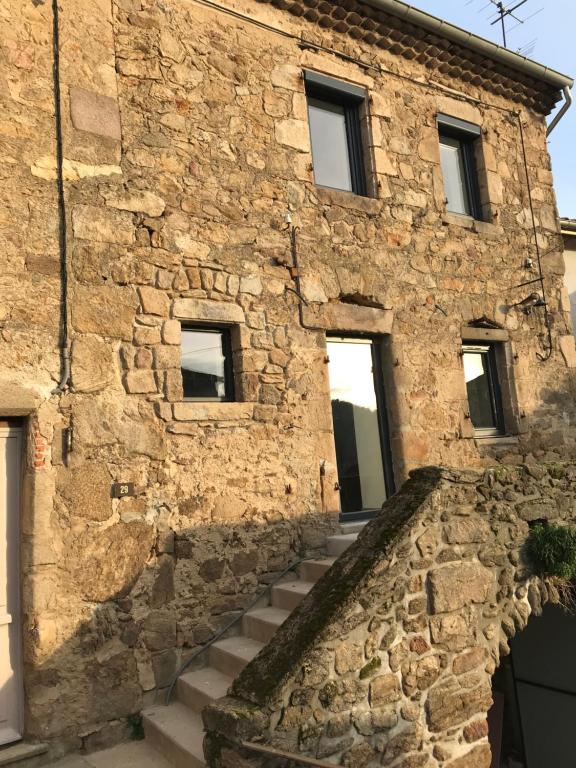 a stone house with stairs in front of it at La Voûte - Maison de charme in Saint-Clair