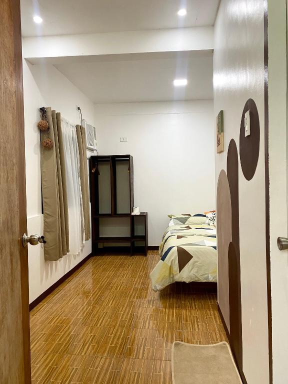 a bedroom with a bed and a wooden floor at Moalboal Panagsama beach TopBudz Hostel in Moalboal