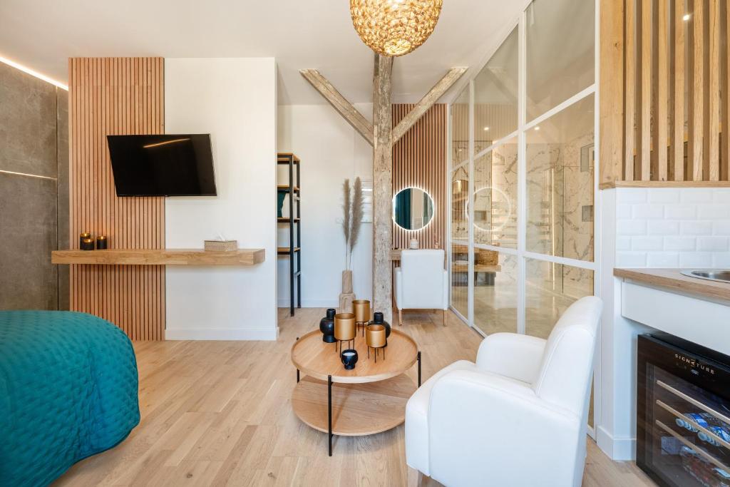 un salon avec un canapé blanc et une table dans l'établissement Studio Chic Sauna et bain Spa, à Vailly-sur-Aisne