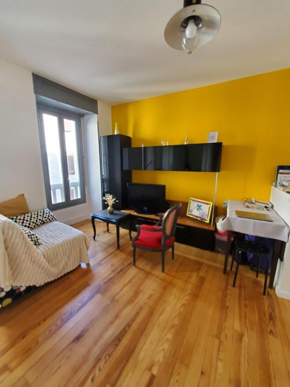 une chambre avec un lit, un bureau et un piano dans l'établissement Studio cosy classé 3 étoiles dans cœur historique, à Arreau