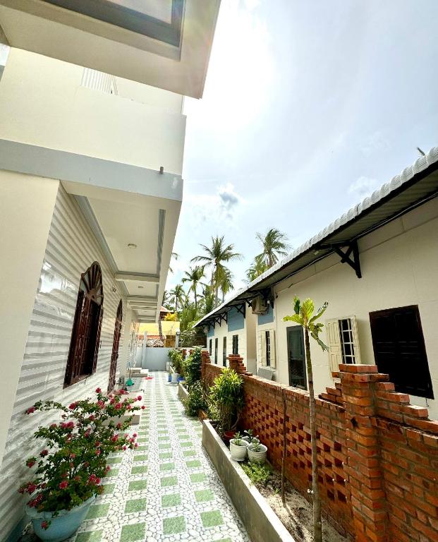a courtyard of a house with flowers and a fence at Xuan Luom Guesthouse in Phan Thiet
