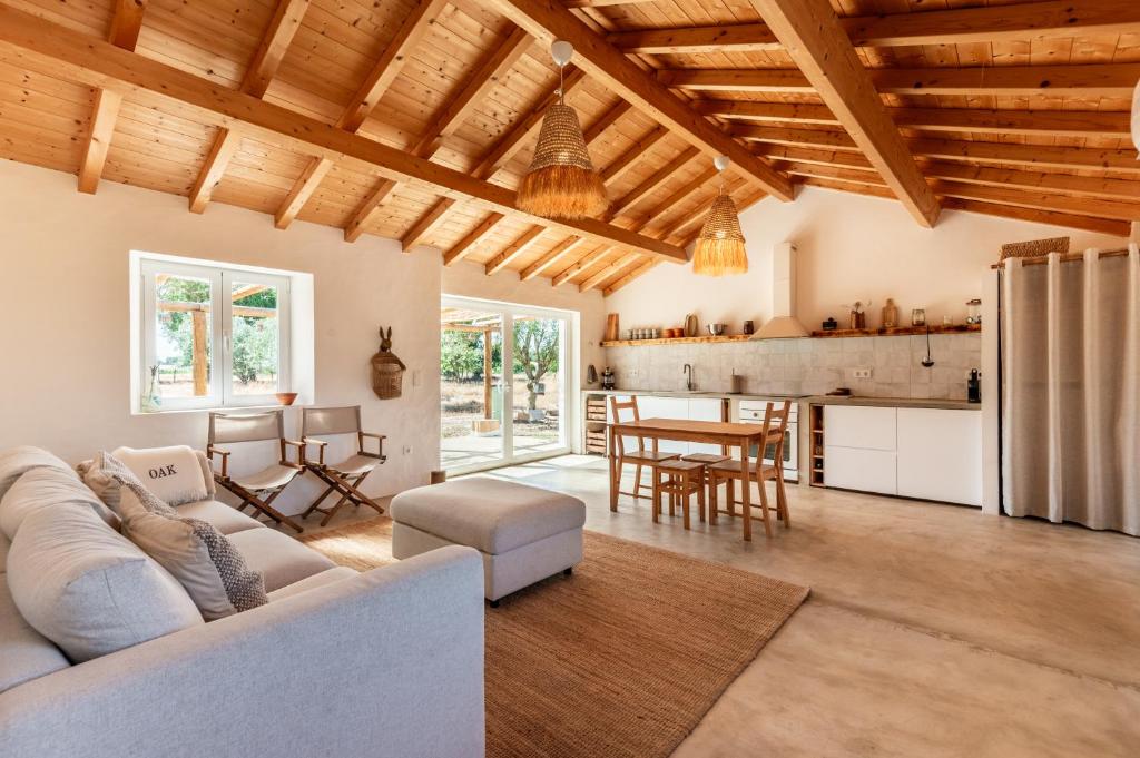 a living room with a white couch and a kitchen at OAK Monte Alentejano - 2 casas T2 alugadas sempre em simultâneo toda a propriedade é exclusiva a uma só reserva in Santiago do Cacém
