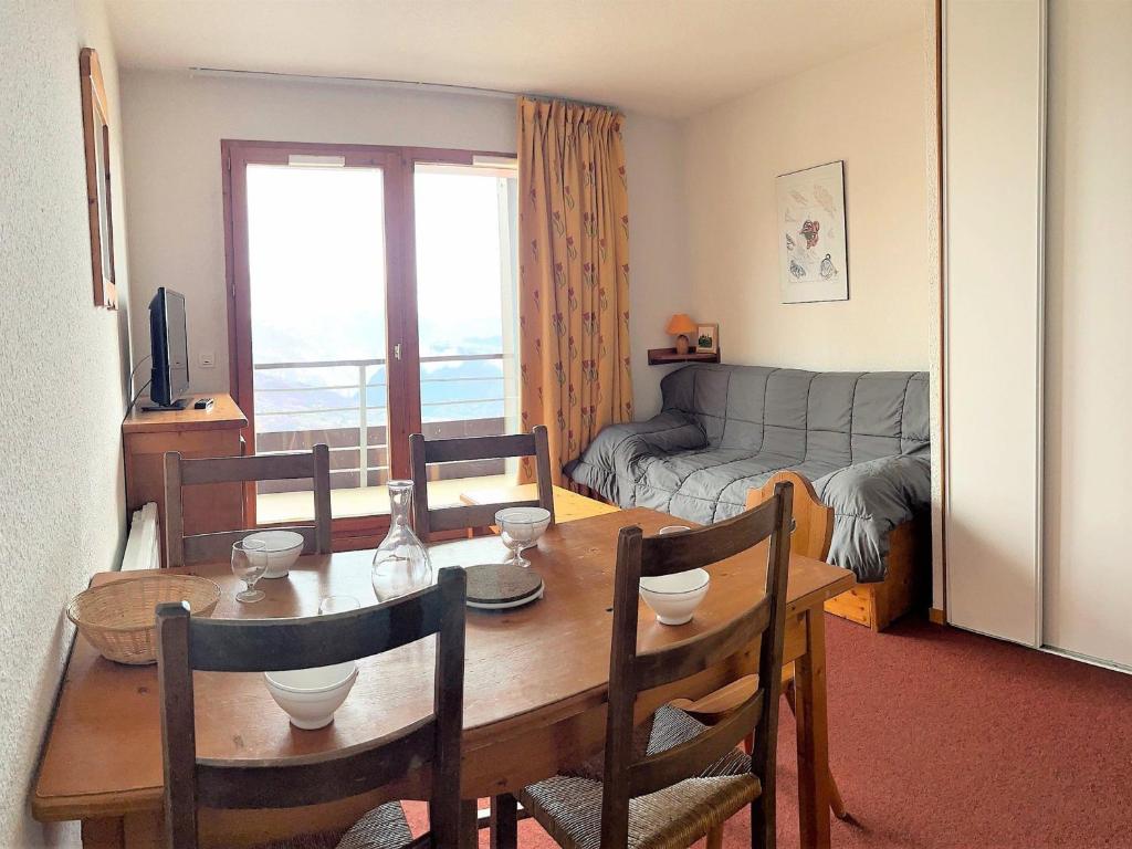 un salon avec une table, des chaises et un canapé dans l'établissement Appartement tout confort avec balcon, skis aux pieds, piscine chauffée, proche commerces et remontées mécaniques - FR-1-267-231, au Corbier
