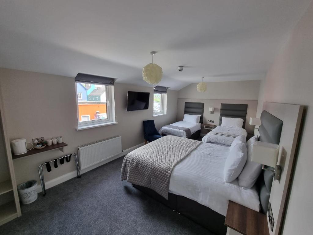 a bedroom with two beds and a tv in it at Murphy's Pub and Bed & Breakfast in Dingle