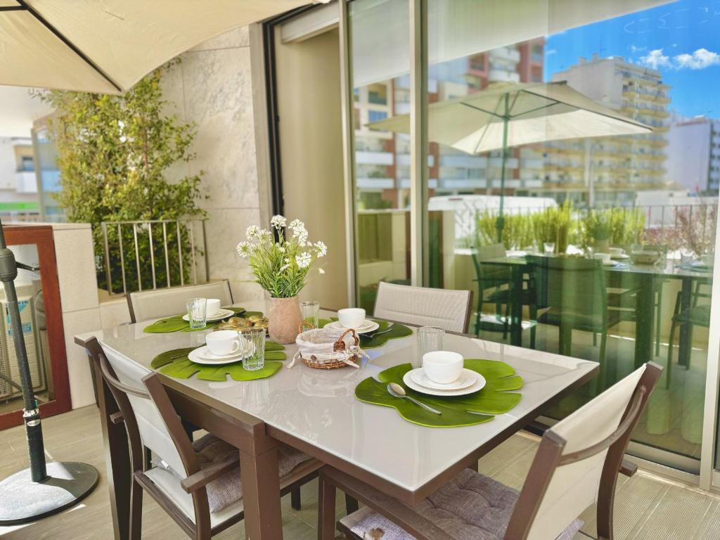 a dining room table with chairs and a white table sidx sidx sidx at DLux Terrace Cond Bayline Pool & SPA in Armação de Pêra