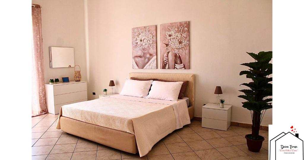 a bedroom with a bed and two paintings on the wall at Teresa Daina Casa dolce casa in Siculiana