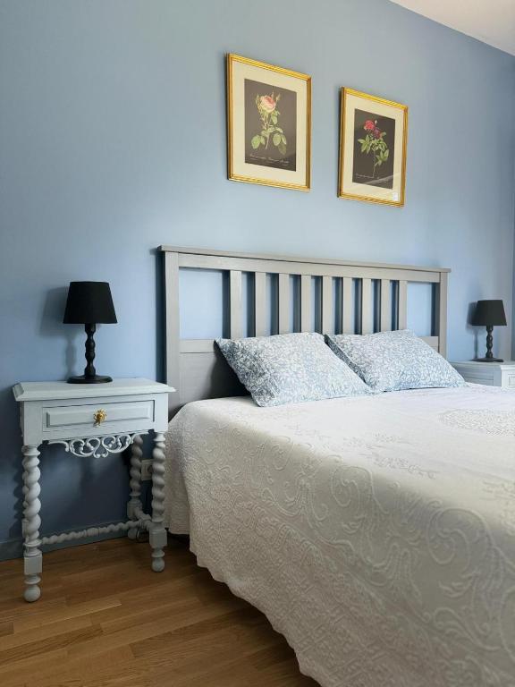 a blue bedroom with a bed and a table with a lamp at Jardim de Cascais in Cascais