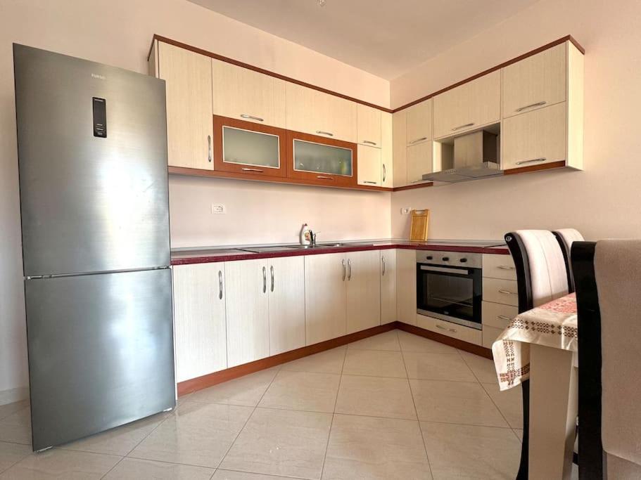 a kitchen with white cabinets and a stainless steel refrigerator at Sea view appartment lungomare in Vlorë