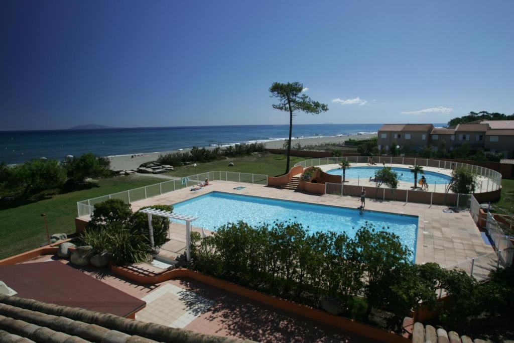 a swimming pool with the ocean in the background at Résidence Cala Bianca in Borgo