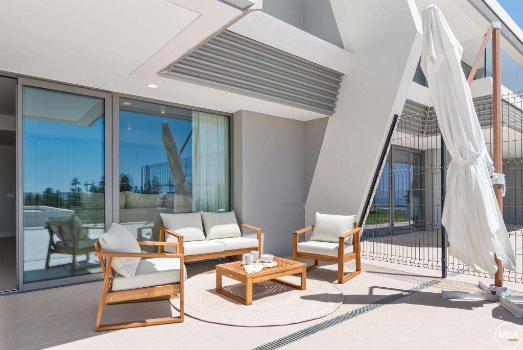 un soggiorno con sedie e un tavolo di ViVi Homes - Marisol Pool, Sauna, Gym, Spa & Beach a Mijas Costa