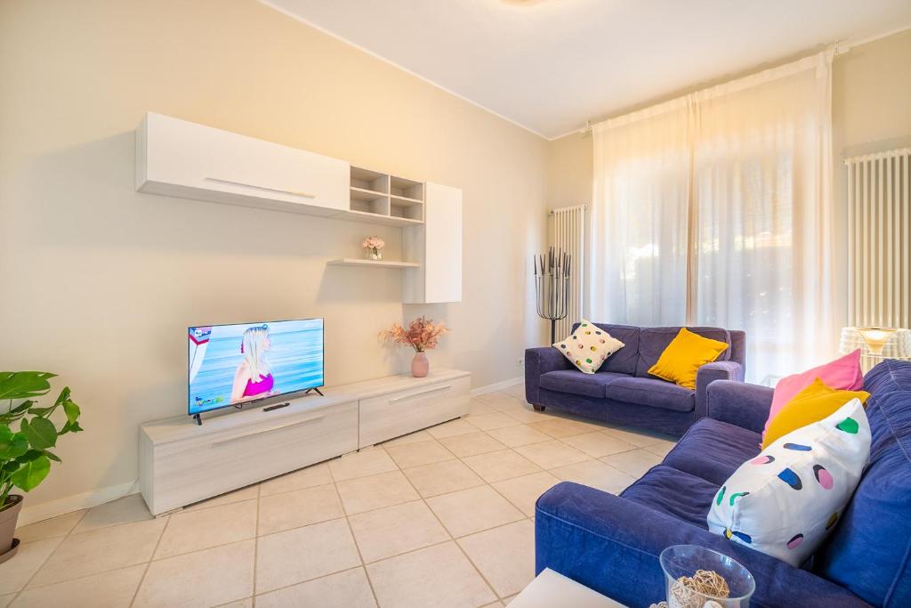 a living room with a blue couch and a tv at La Villetta delle Stelle in Viareggio