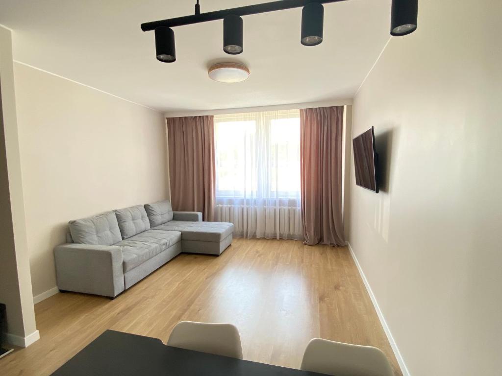 a living room with a couch and a table at Cosy Guest Apartment Gdynia in Gdynia