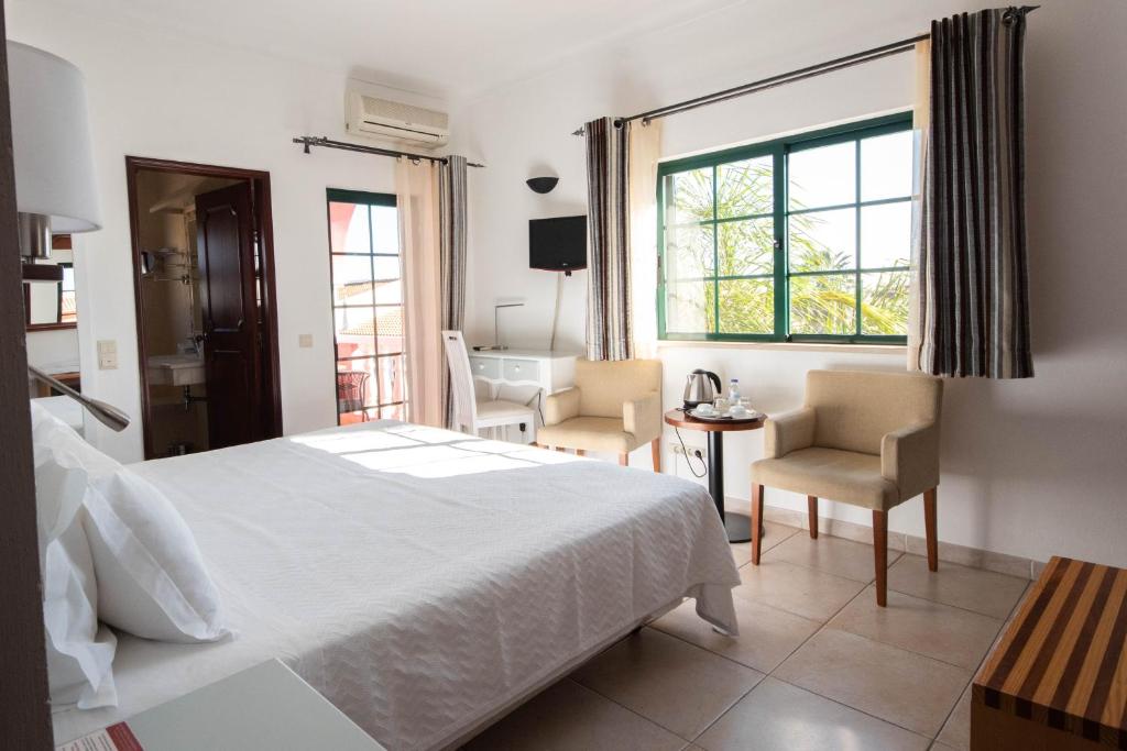a bedroom with a bed and a table and chairs at Solar de Mos in Lagos