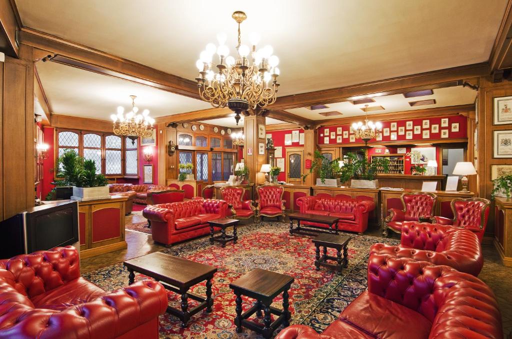 a lobby with red leather furniture and a bar at Hotel Città Dei Mille in Bergamo