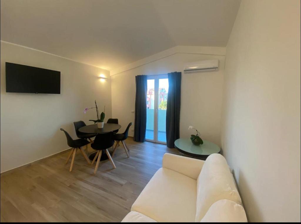 a living room with a white couch and a table at Casa vacanze in Quartu SantʼElena