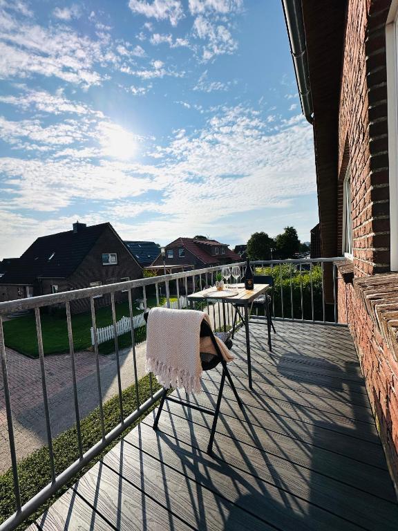 a chair sitting on a balcony with a table at Casa del Sol - Ferienwohnung Norddeich in Norddeich