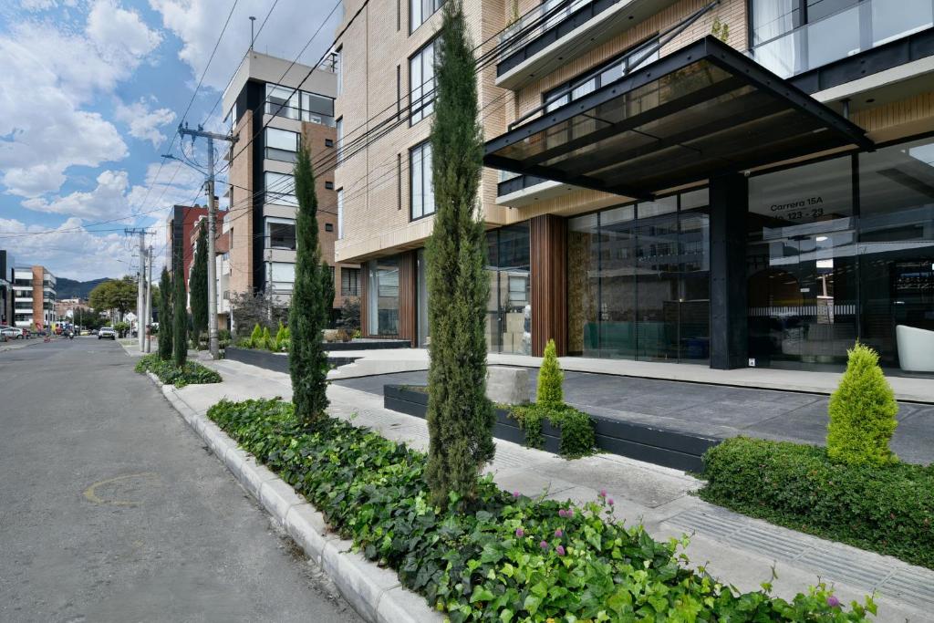 a building with trees in front of a street at Neo by Wynwood House in Bogotá