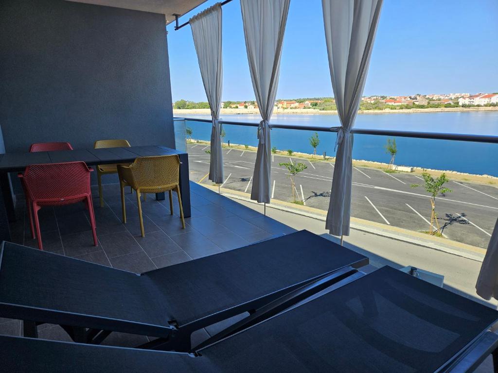 een kamer met een tafel en stoelen en een groot raam bij APARTMAN SUNSIDE2 NIN in Nin