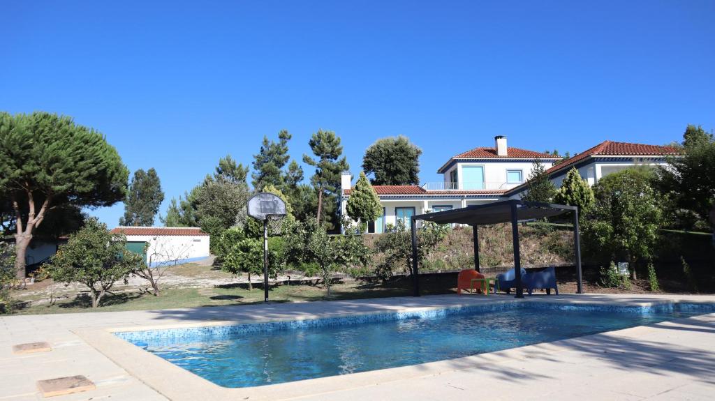 a swimming pool in front of a house at Casa Azul in Vila de Rei