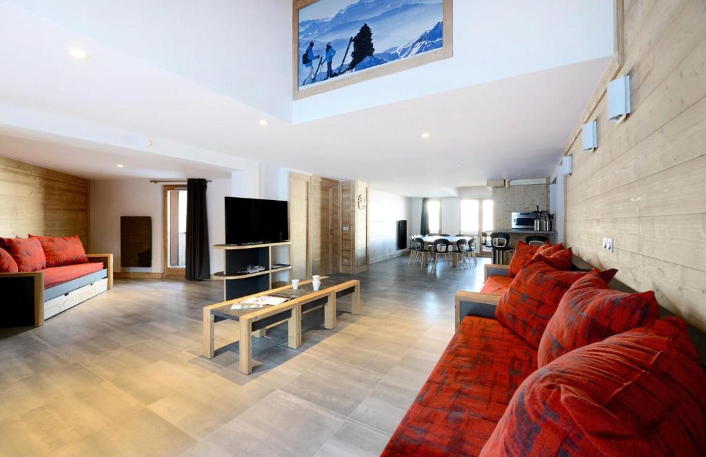 un salon avec un canapé rouge et une table dans l'établissement Résidence Backgammon - LE BACKGAMMON MAE-3414, à Les Coches