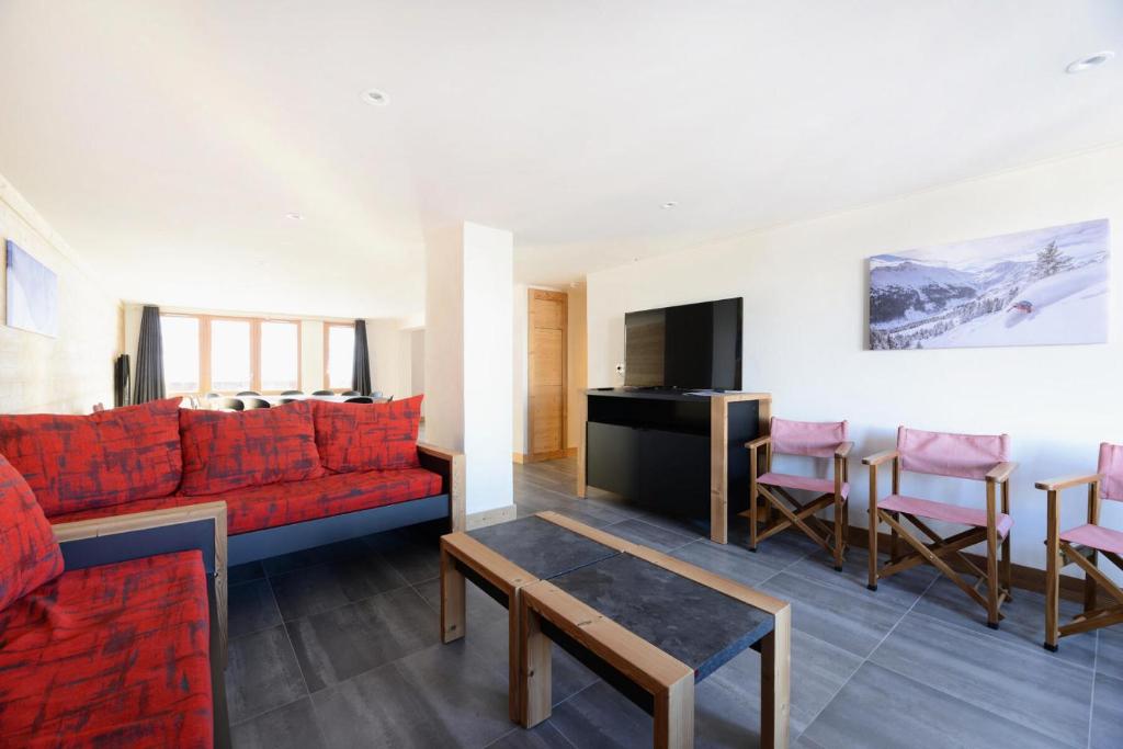 un salon avec un canapé rouge et une table dans l'établissement Résidence Backgammon - LE BACKGAMMON MAE-3418, à Les Coches