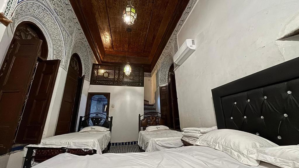 una camera con due letti e un soffitto di Dar El Arfaoui a Fes