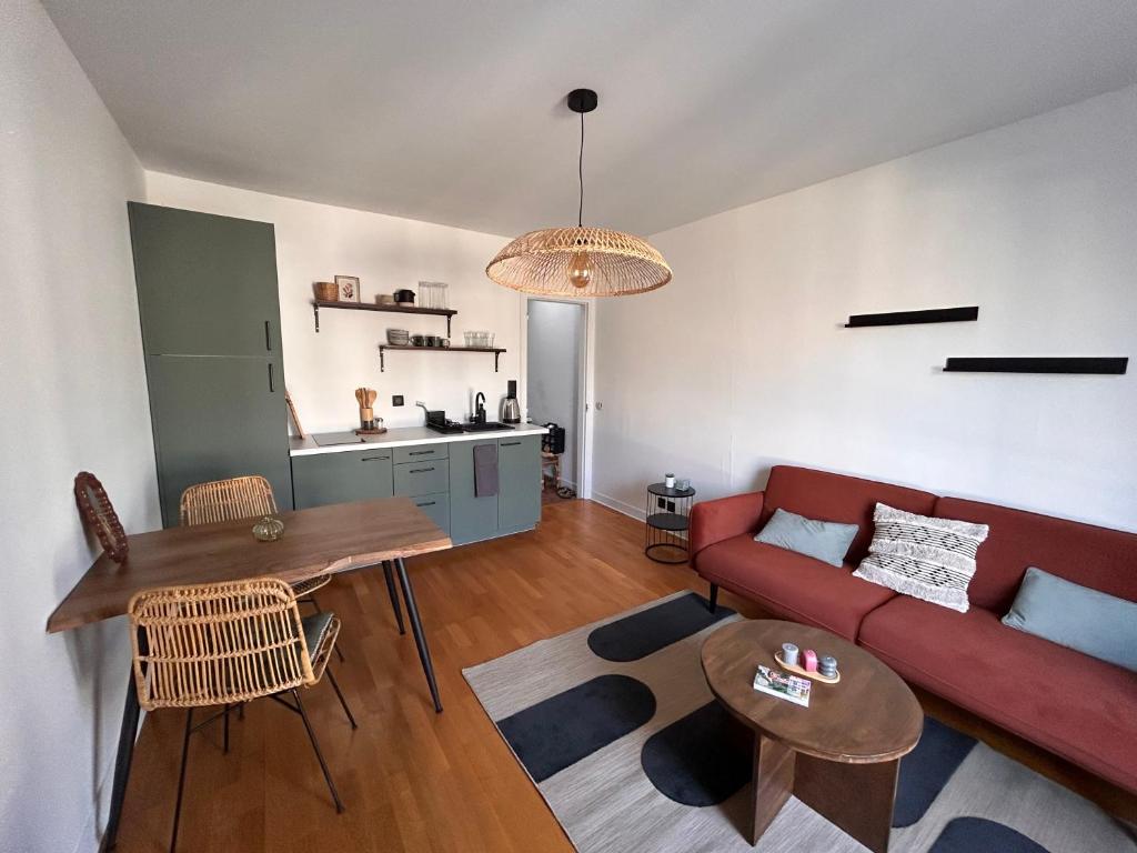 un salon avec un canapé rouge et une table dans l'établissement Renovated flat near Tour Eiffel, à Paris