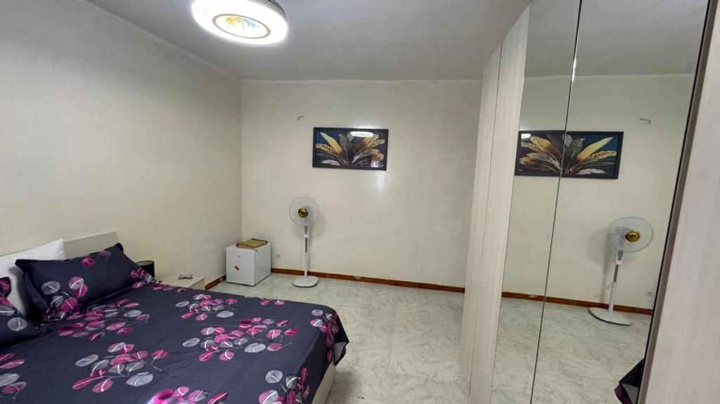 arsa taranga في داكار: غرفة نوم بسرير أرجواني ومروحتين