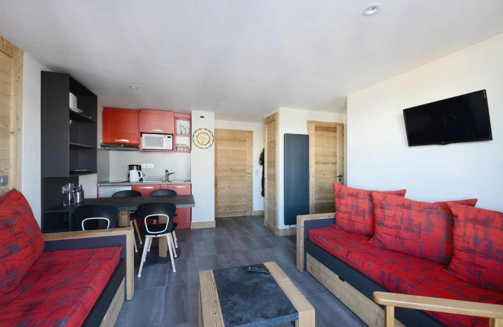 un salon avec un canapé rouge et une cuisine dans l'établissement Résidence Backgammon - RESIDENCE LE BACKGAMMON MAE-3511, à Les Coches