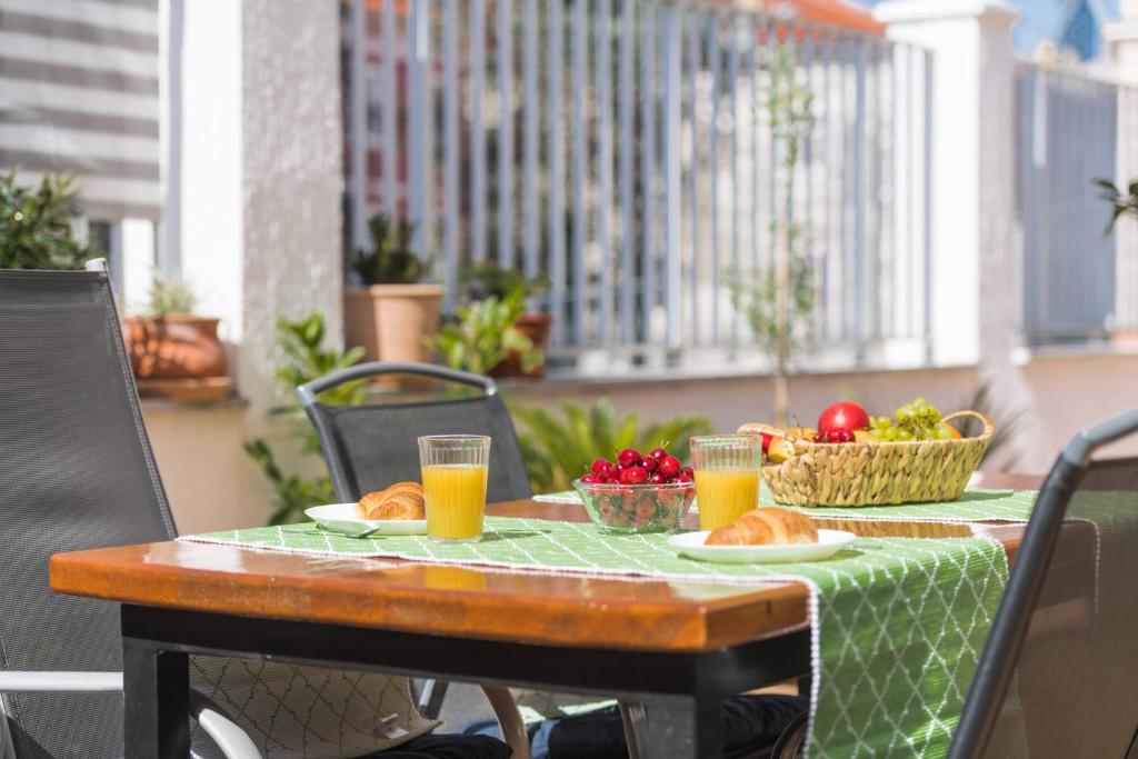 a table with food and drinks on a balcony at Porta Aurea sunny studio in Pula