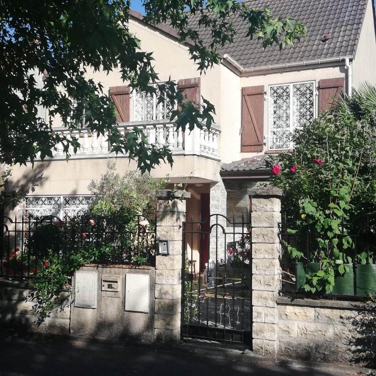 une maison avec un portail et une clôture fleurie dans l'établissement Fastrentbnb Villepinte chambre cozy, à Villepinte