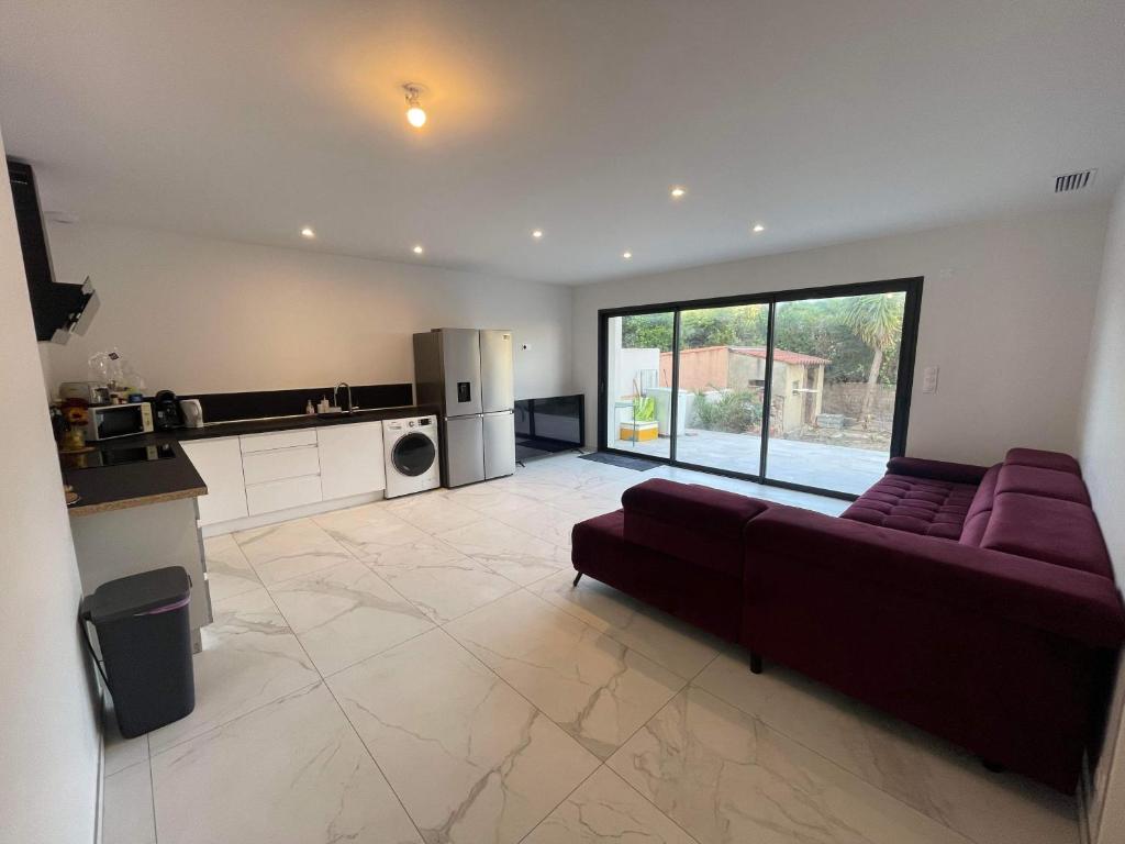 Il comprend un grand salon avec un canapé et une cuisine. dans l'établissement Grand appt rdc Saint-Cyprien plage, à Saint-Cyprien